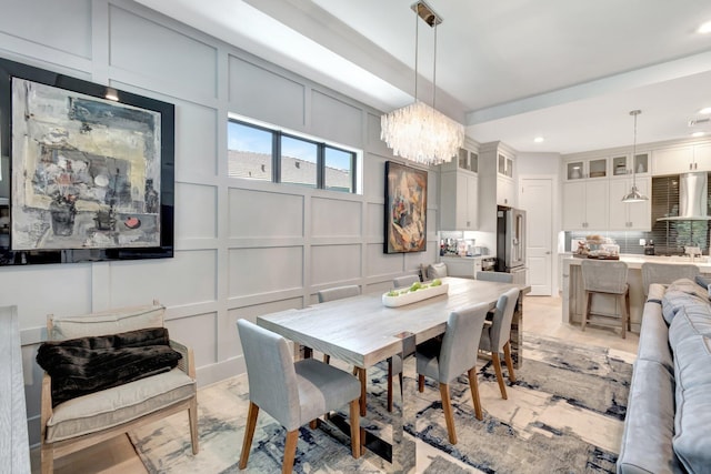 dining area featuring a decorative wall, recessed lighting, and a chandelier