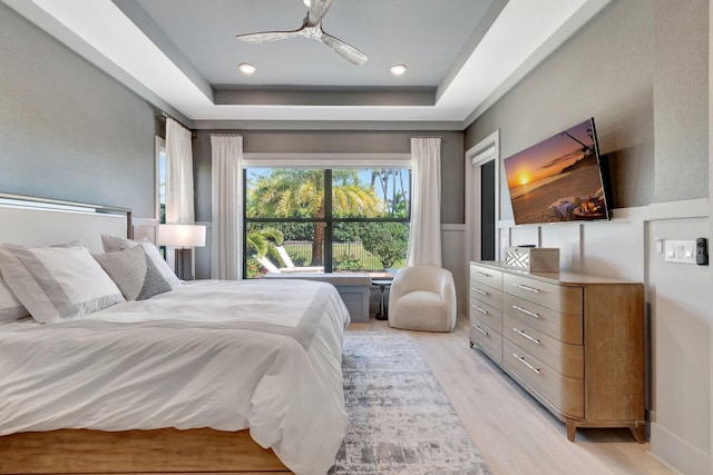 bedroom with recessed lighting, a ceiling fan, a raised ceiling, and light wood-style floors