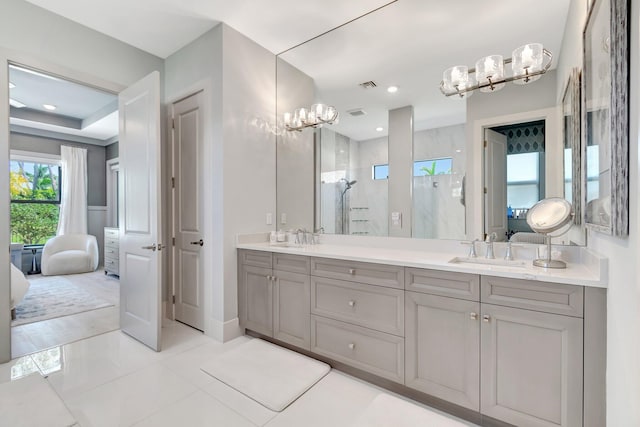 ensuite bathroom with a sink, a marble finish shower, and ensuite bathroom