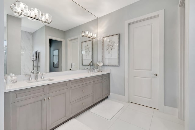 bathroom with tile patterned floors, double vanity, baseboards, and a sink