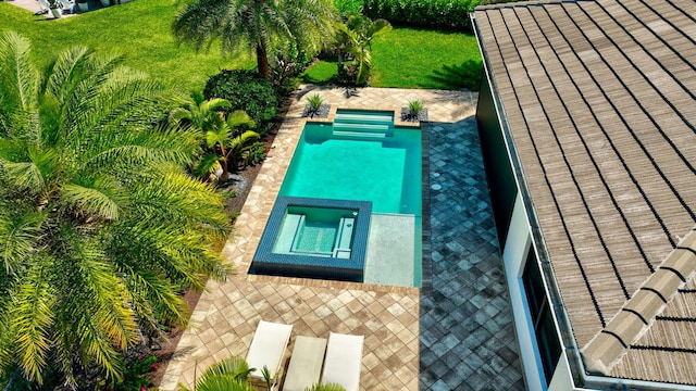 view of pool featuring a yard, a patio area, and a pool with connected hot tub