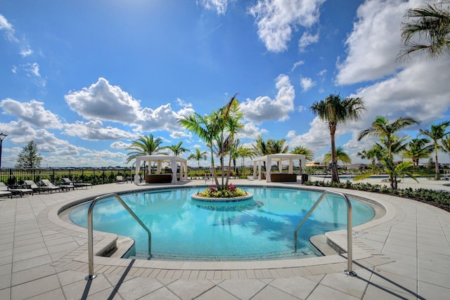 community pool with a patio, fence, and a pergola