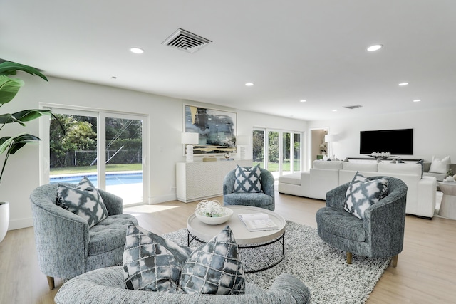 living area featuring recessed lighting, visible vents, and light wood finished floors