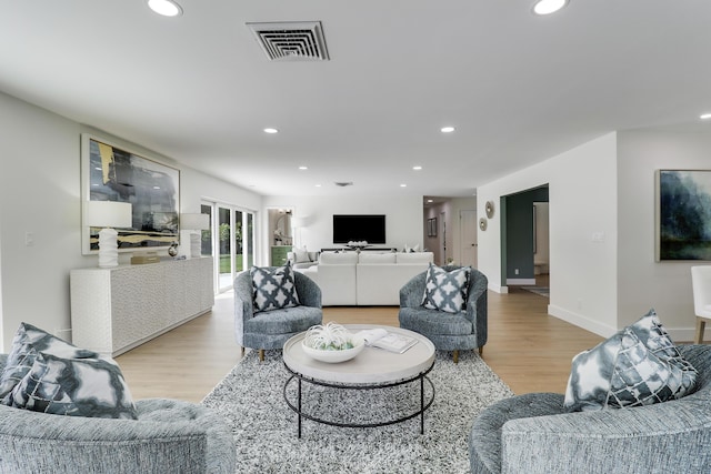 living room featuring recessed lighting, visible vents, and wood finished floors