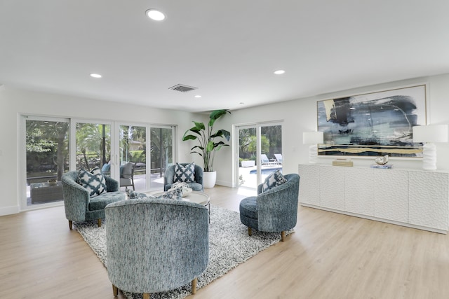 living room with recessed lighting, light wood-style floors, visible vents, and baseboards