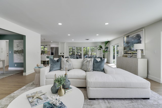 living room featuring a wealth of natural light, baseboards, light wood-style floors, and recessed lighting