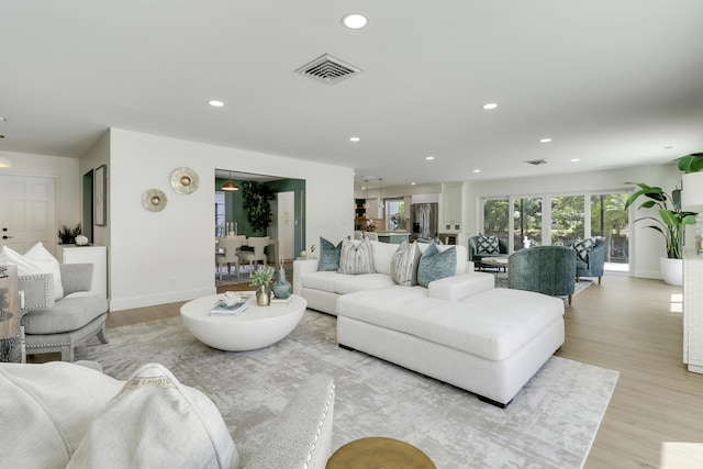 living area with baseboards, recessed lighting, visible vents, and light wood-type flooring