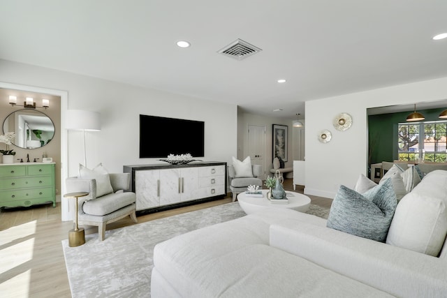 living area with visible vents, recessed lighting, light wood-type flooring, and baseboards