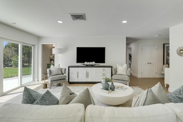 living area featuring light wood finished floors, visible vents, recessed lighting, and baseboards