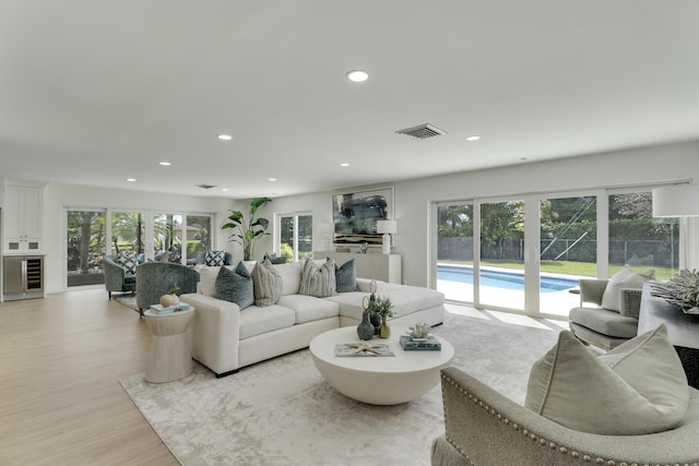 living room featuring visible vents, wine cooler, recessed lighting, light wood-style floors, and plenty of natural light