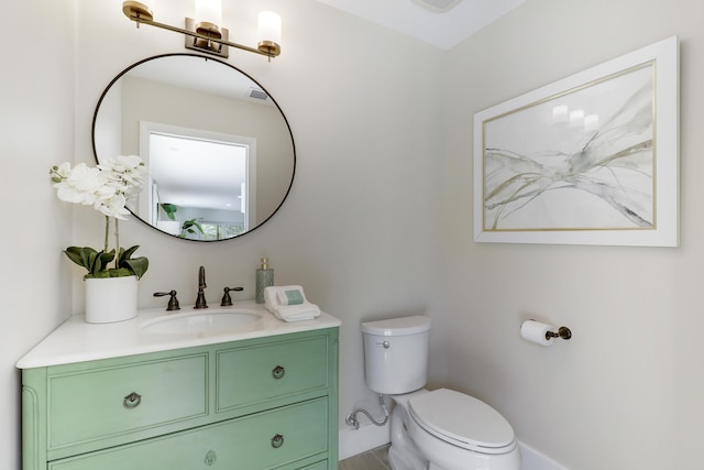 half bath with toilet, vanity, and baseboards