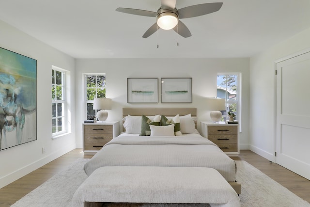 bedroom featuring light wood-type flooring, baseboards, and ceiling fan