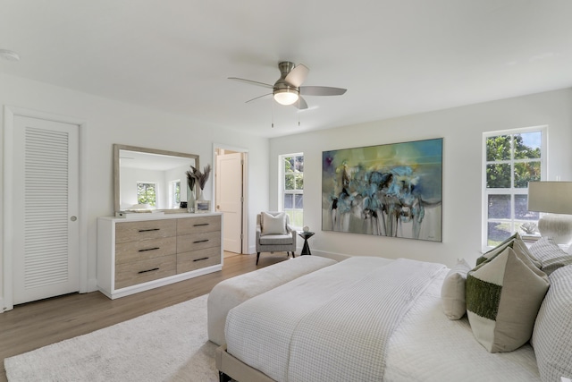 bedroom with a ceiling fan, light wood-type flooring, and baseboards