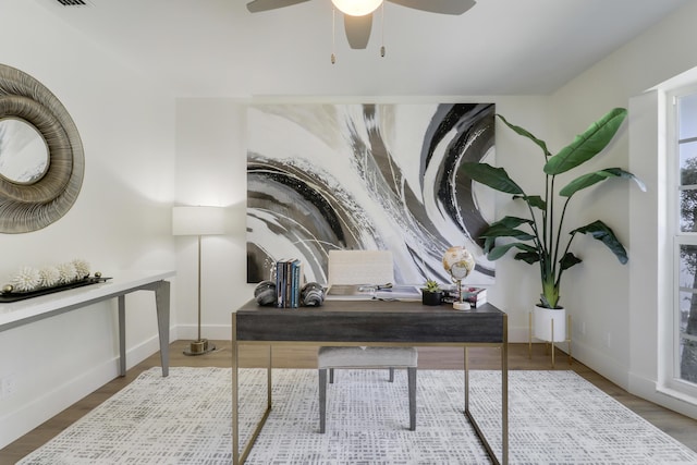 office space featuring wood finished floors, baseboards, and ceiling fan