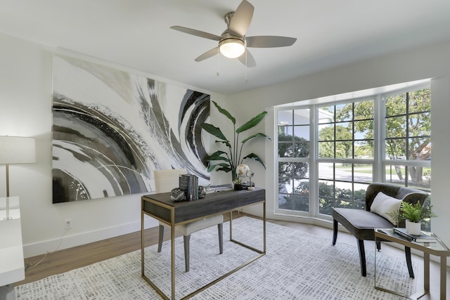 office area with wood finished floors, baseboards, and ceiling fan