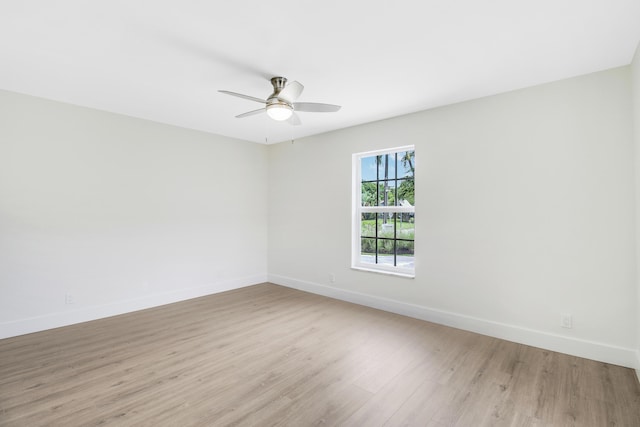 unfurnished room with baseboards, light wood-style floors, and a ceiling fan