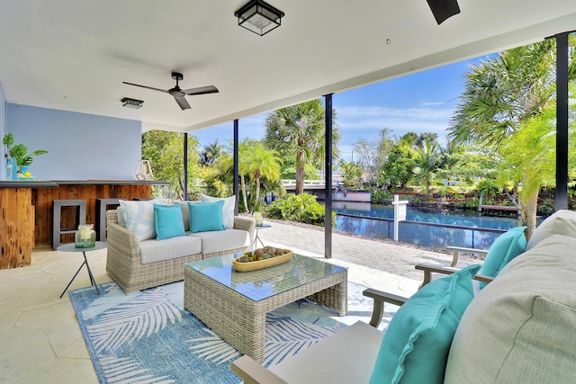 sunroom with a water view and ceiling fan