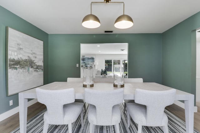 dining space featuring visible vents, baseboards, and wood finished floors