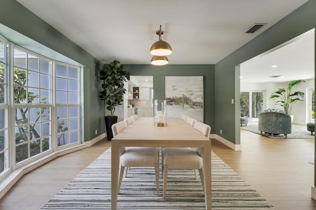 dining space with visible vents, baseboards, and light wood-style flooring