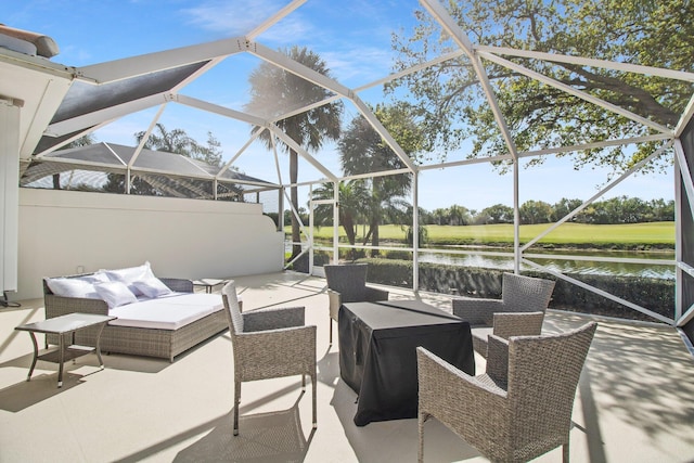 view of patio / terrace featuring glass enclosure, a water view, and an outdoor hangout area