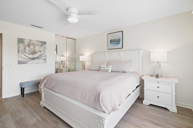 bedroom with visible vents, a ceiling fan, a closet, light wood-style floors, and baseboards