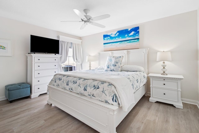 bedroom featuring light wood-style flooring, a ceiling fan, and baseboards