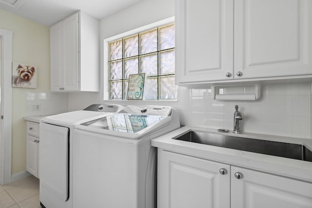 laundry area with a sink, light tile patterned flooring, cabinet space, and washing machine and clothes dryer