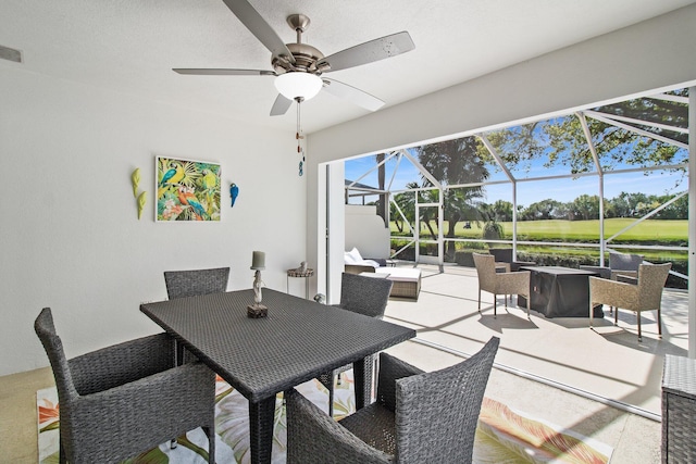 dining space with a ceiling fan and a sunroom