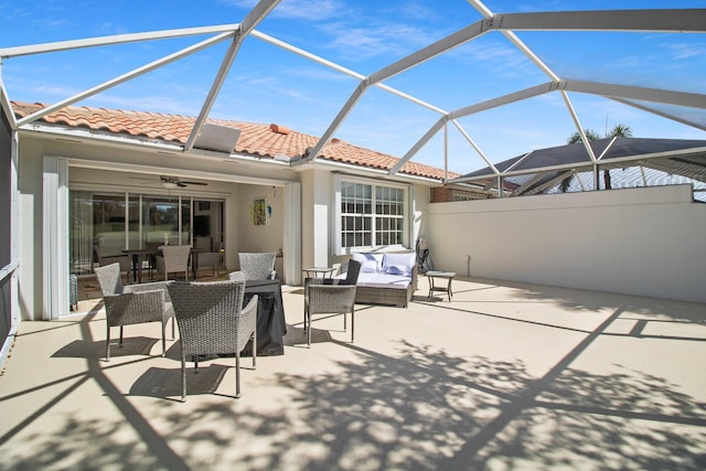 view of patio / terrace with glass enclosure, outdoor lounge area, and a ceiling fan