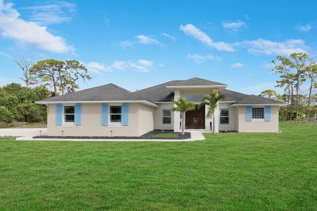 view of front of house featuring a front lawn and stucco siding