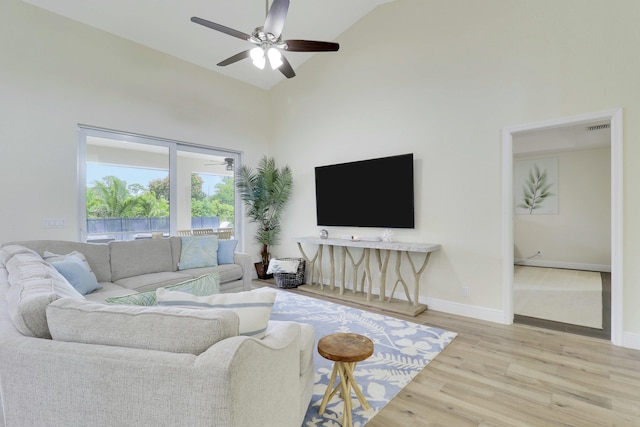 living room with visible vents, baseboards, ceiling fan, wood finished floors, and high vaulted ceiling