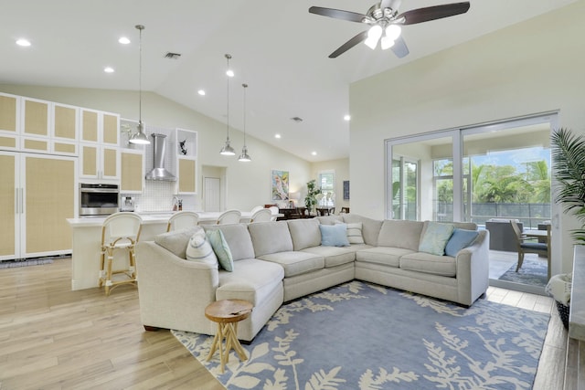 living area with high vaulted ceiling, light wood-type flooring, visible vents, and recessed lighting