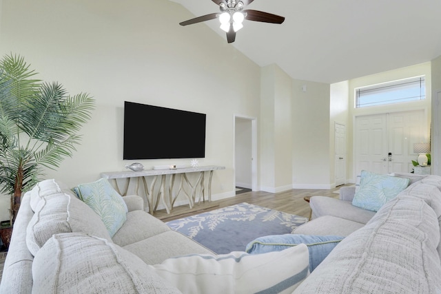 living area with high vaulted ceiling, wood finished floors, a ceiling fan, and baseboards