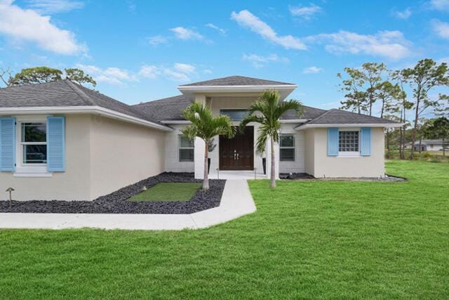 view of front of property with a front yard and stucco siding