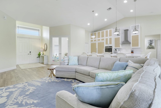 living room with high vaulted ceiling, french doors, visible vents, and light wood-style floors