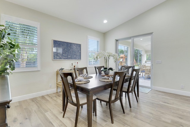 dining space with lofted ceiling, light wood-style floors, baseboards, and recessed lighting