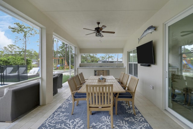 sunroom featuring lofted ceiling and ceiling fan