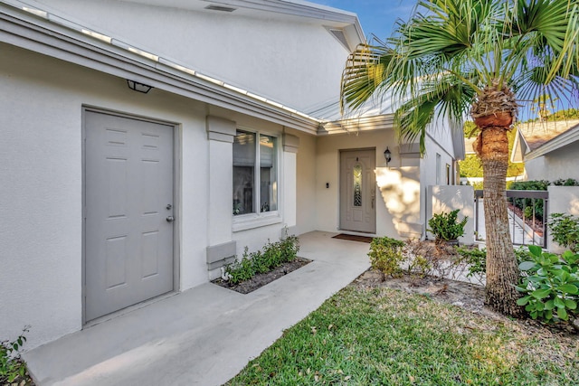 doorway to property featuring stucco siding