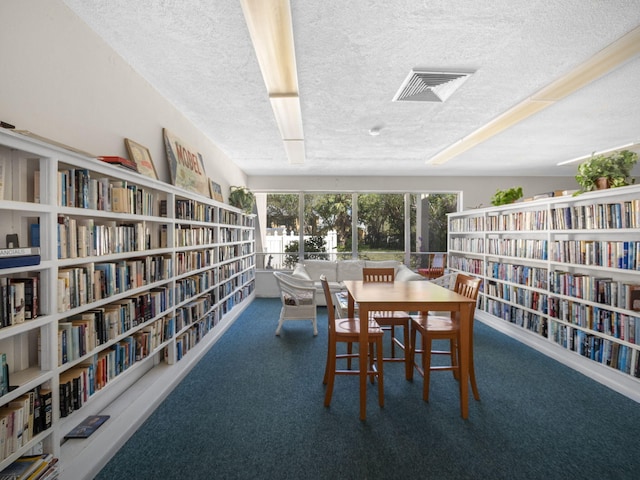 dining area featuring visible vents, a textured ceiling, and carpet flooring