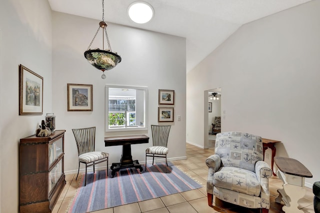 sitting room with light tile patterned flooring, high vaulted ceiling, and baseboards