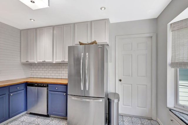 kitchen featuring butcher block countertops, blue cabinetry, tasteful backsplash, recessed lighting, and stainless steel appliances