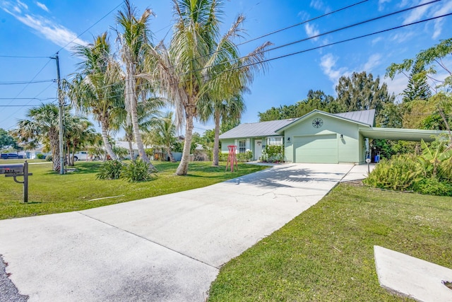 ranch-style house featuring metal roof, an attached garage, concrete driveway, and a front lawn