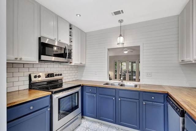 kitchen featuring blue cabinets, visible vents, a sink, appliances with stainless steel finishes, and wooden counters