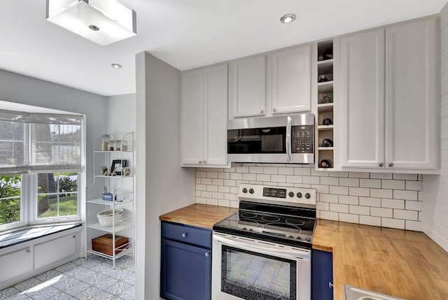 kitchen featuring stainless steel appliances, wood counters, blue cabinets, and open shelves