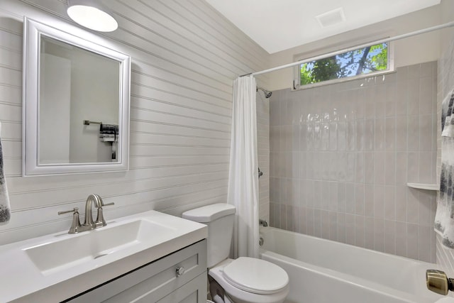 bathroom with vanity, toilet, shower / bathtub combination with curtain, and visible vents