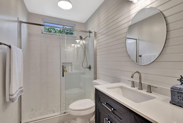 bathroom with toilet, a stall shower, and vanity