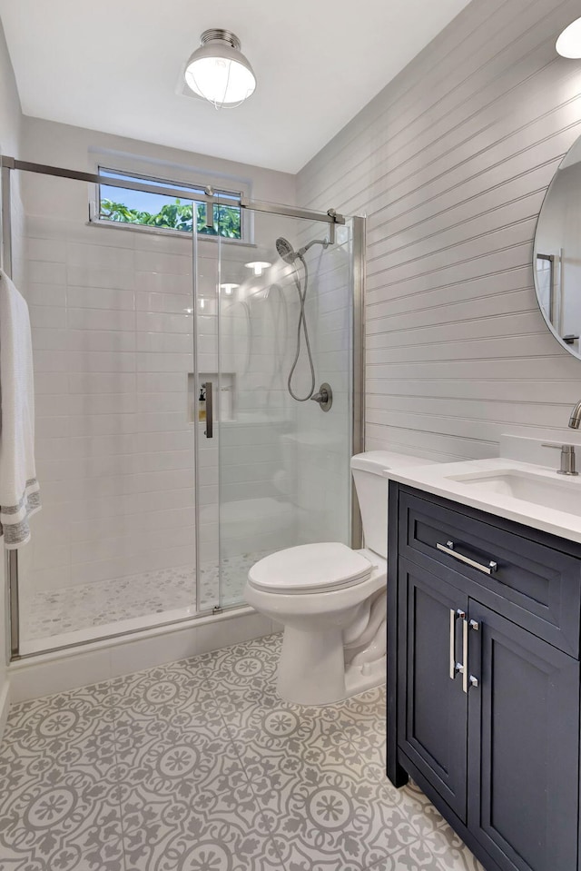 bathroom with tile patterned flooring, a shower stall, toilet, and vanity