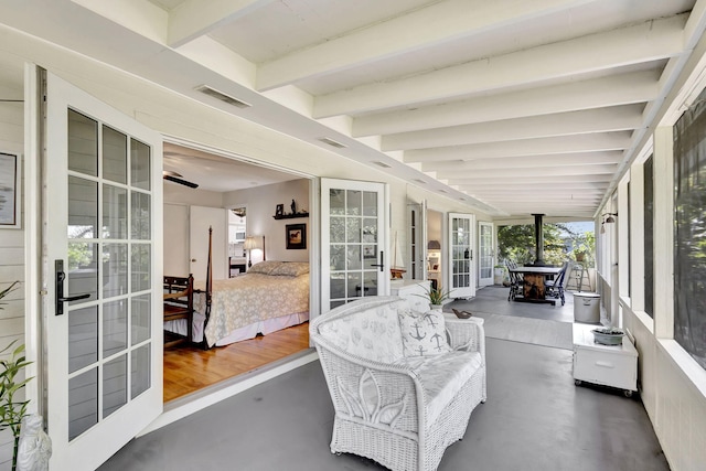 sunroom / solarium featuring beamed ceiling, french doors, and visible vents