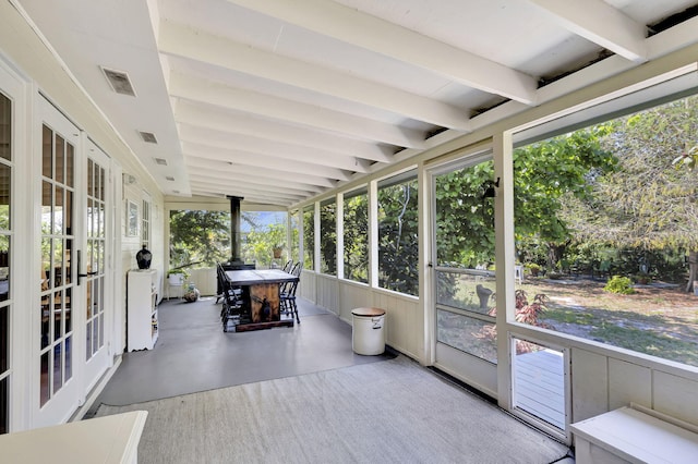 unfurnished sunroom with visible vents and beamed ceiling