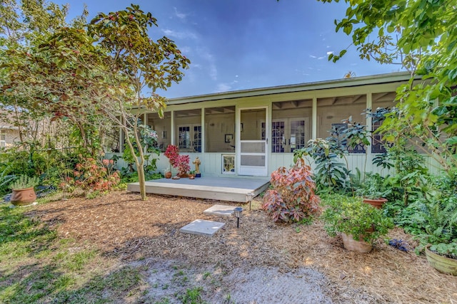 view of front of property with french doors, a deck, and a sunroom